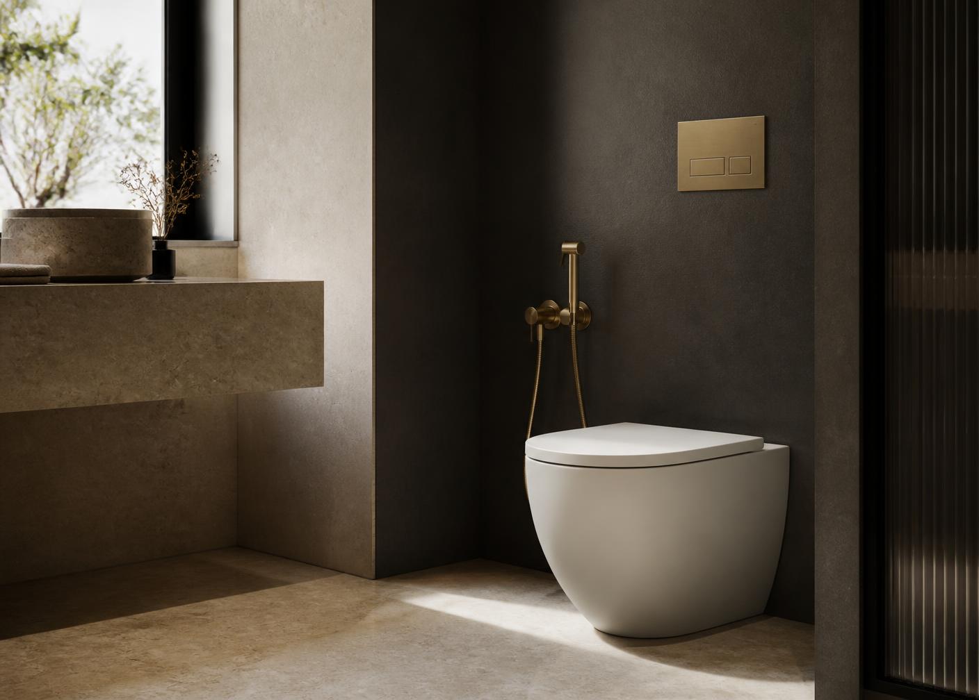 Minimal bathroom with a wall-mounted brass hand bidet beside a modern toilet
